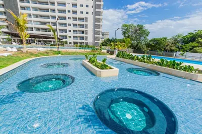a swimming pool with blue tiles on the ground at Apto nuevo Frente al Mar con Piscina Wifi cerca aeropuerto in Santa Marta