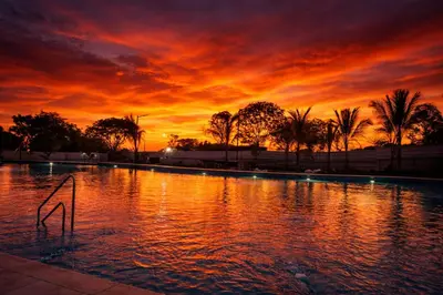 a large pool with a sunset in the background at Apto nuevo Frente al Mar con Piscina Wifi cerca aeropuerto in Santa Marta