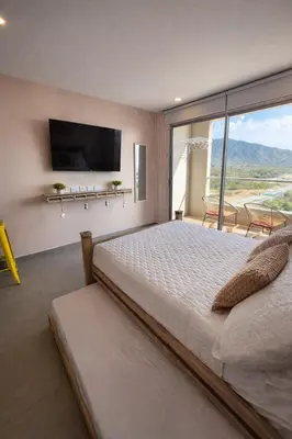 a bedroom with a large bed and a large window at Apto nuevo Frente al Mar con Piscina Wifi cerca aeropuerto in Santa Marta