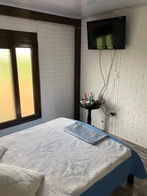 a bedroom with a bed with a tv on the wall at La Dolce Villa! in El Mamey