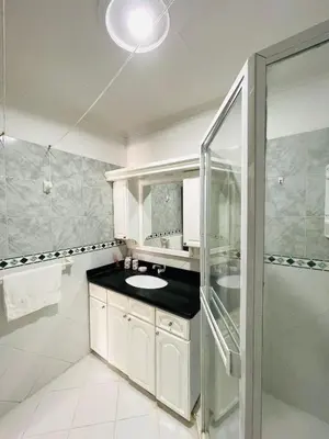 a white bathroom with a sink and a shower at Two Bedroom Apt in Cartagena de Indias