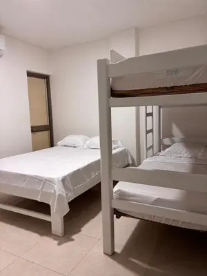 a bedroom with two bunk beds and a mirror at Apartamento familiar en coveñas cerca del mar in Coveñas