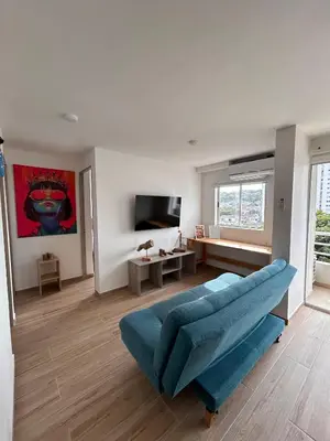 a living room with a blue couch and a tv at New apartment 5 minutes from the beach in Cartagena de Indias