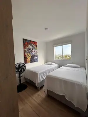 a bedroom with two beds and a painting on the wall at New apartment 5 minutes from the beach in Cartagena de Indias