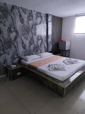 a large bed in a room with a wall at Hotel El Tesoro in Barranquilla