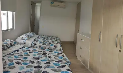 a bedroom with two beds and a dresser at Apto Coveñas in Coveñas