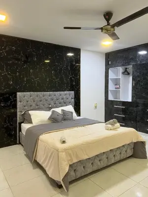 a bedroom with a large bed with a black wall at Rojas House in Barranquilla