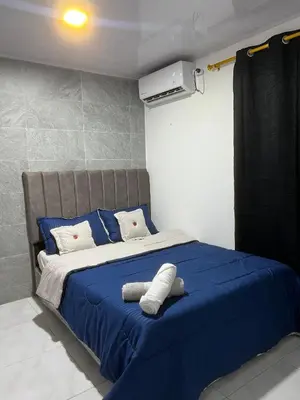 a bedroom with a blue bed with blue and white pillows at Rojas House in Barranquilla