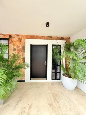 a room with a black door and two plants at Private loft near the airport with fast WiFi in Cartagena de Indias