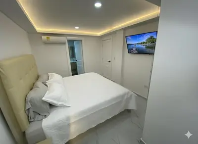 a bedroom with a bed and a tv on the wall at Apto de 3 habitaciones cerca del areopuerto de CTG in Cartagena de Indias