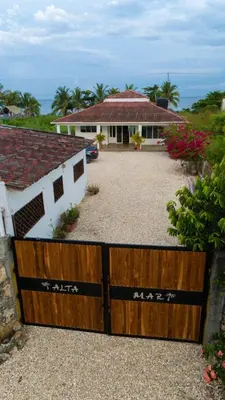 a house with a wooden gate in front of a driveway at Country cabin, Coveñas in Coveñas