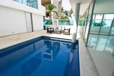 a swimming pool with two chairs and a house at Luxury House Cartagena Private pool in Cartagena de Indias