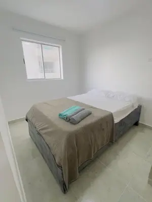 a white bedroom with a bed with a blanket at Beach Lotus 1203 in Cartagena de Indias