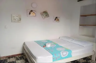 a small bed in a room with pictures on the wall at Hotel Palma Azul in Coveñitas