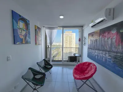 a living room with chairs and a large window at Acogedor Apto Cerca A La Playa WiFi Piscina AC in Cartagena de Indias