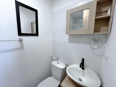 a bathroom with a white toilet and a sink at Acogedor Apto Cerca A La Playa WiFi Piscina AC in Cartagena de Indias