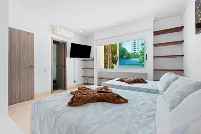 a bedroom with two beds and a flat screen tv at 10BR Mansion Beachfront w Pool and Disco in Cartagena de Indias