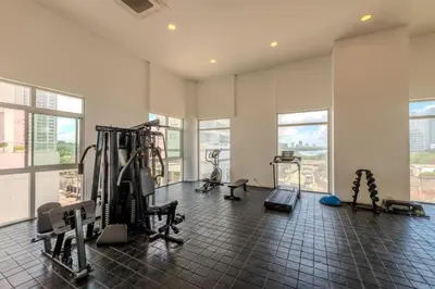 a gym with treadmills and machines in a room with windows at Apartamento a pasos del mar y centro en Cartagena, piscina sauna & turco in Cartagena de Indias