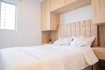a bedroom with a bed with white sheets and a window at Luxury apartment with ocean view 15th floor in Cartagena de Indias