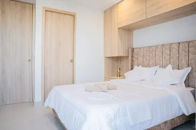 a bedroom with a large bed with white sheets at Luxury apartment with ocean view 15th floor in Cartagena de Indias