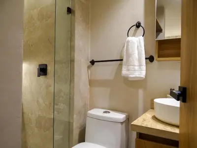a bathroom with a toilet and a glass shower at Apto chic con AC 3 hab 2 baños cerca al Mar in Cartagena de Indias