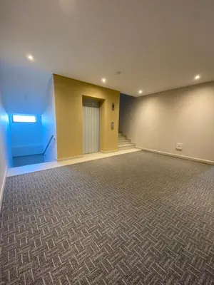 a large room with blue walls and a hallway at BQ84 Urban Hotel in Barranquilla