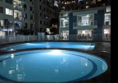 a large blue swimming pool in front of a building at Cómoda habitación cerca de la via 40 Carnaval Barranquilla in Barranquilla