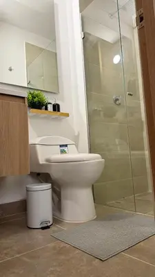 a bathroom with a toilet and a glass shower at Apartamento acogedor y tranquilo cerca del mar in Cartagena de Indias