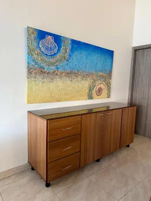 a cabinet in a room with a painting on the wall at Cozy Apartment Near Airport, Beaches & Old City in Cartagena de Indias
