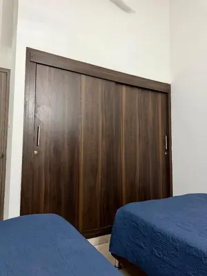 a bedroom with a wooden cabinet and a bed at Cozy Apartment Near Airport, Beaches & Old City in Cartagena de Indias