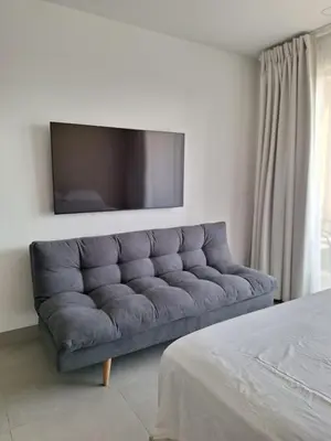 a couch in a living room with a tv on the wall at Santa Marina Modern Loft Santa Marta in Santa Marta