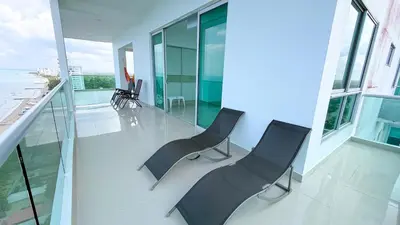 a room with two chairs and a table on a balcony at Magico Apartamento Frente al Mar 5 Habitaciones OS121 in Coveñitas