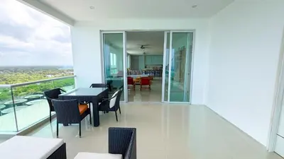 a balcony with tables and chairs and a dining room at Magico Apartamento Frente al Mar 5 Habitaciones OS121 in Coveñitas