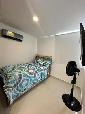 a small bedroom with a bed and a fan at Apartamento a 5 min del cc Buena Vista in Barranquilla