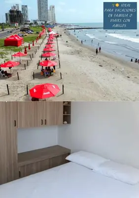 a beach with red umbrellas and the ocean at Apartamento para familias cerca de la playa y sitios turísticos in Cartagena de Indias