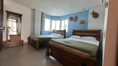 two beds in a bedroom with blue walls at Vive al estilo Cartagenero frente al mar y al lago in Cartagena de Indias