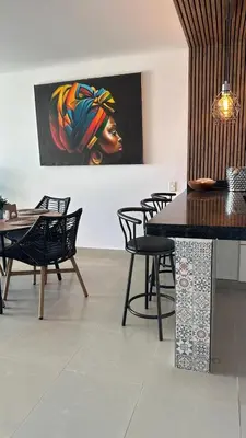 a dining room with chairs and a painting on the wall at Vive al estilo Cartagenero frente al mar y al lago in Cartagena de Indias