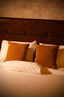a bed with white pillows and brown pillows at Cuna 58 in Barranquilla
