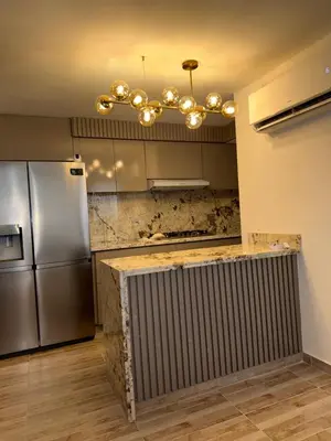 a kitchen with a stainless steel refrigerator and a chandelier at Luxury apartment in Barranquilla