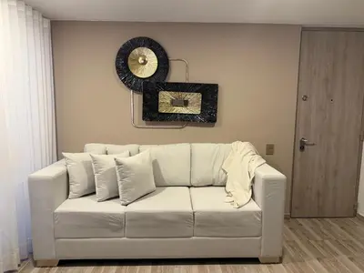 a white couch in a living room with a mirror at Luxury apartment in Barranquilla