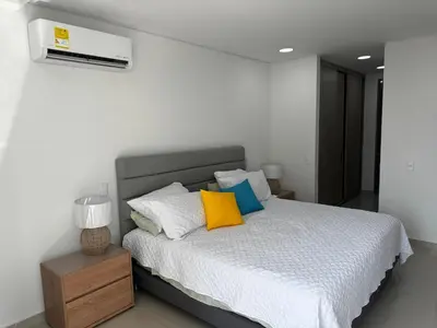 a bedroom with a white bed with colorful pillows at NEW Premium 1BR Apartment in the Best Area in Barranquilla
