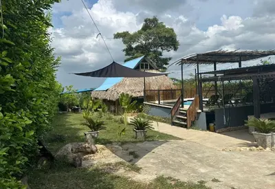 a patio with a black umbrella and a house at Casaroca in Turbaco