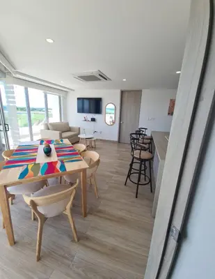 a dining room and living room with a table and chairs at Oceani Tower Cielo Mar Apartment in Cartagena de Indias