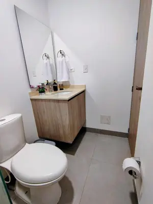 a bathroom with a toilet and a sink and a mirror at Apartamento de lujo en Santa Marta in Santa Marta