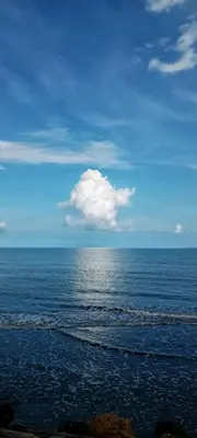 a view of the ocean with a cloud in the sky at El Castillo in Moñitos