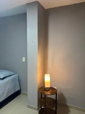 a lamp on a table next to a bed at Gisela Wax More Guess Room in Cartagena de Indias