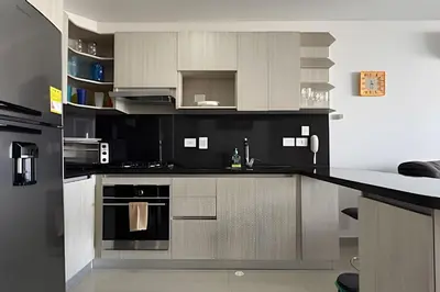 a kitchen with black and white appliances in a room at Hermoso Apto de 1 hab con Vista al Mar - Piso 10 in Cartagena de Indias