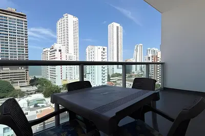 a table on a balcony with a view of a city at Hermoso Apto de 1 hab con Vista al Mar - Piso 10 in Cartagena de Indias