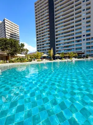 a large blue swimming pool with two tall buildings at Modern Balcony Apartment with Sea View! in Santa Marta