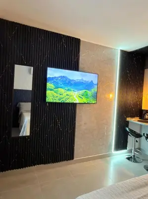 a room with a flat screen tv on a wall at Modern Balcony Apartment with Sea View! in Santa Marta
